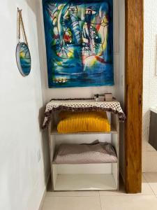 a painting on the wall above a shelf in a room at Pousada Canto Gira Sol Penha SC Estúdio Sol 5 Min do Beto Carrero in Penha