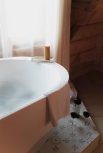 a bathtub with a towel and two glasses of wine at Willa Madejówka - Apartamenty z Widokiem na Góry i Wanną z Jacuzzi in Ząb