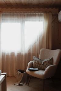 a living room with a chair and a window at Willa Madejówka - Apartamenty z Widokiem na Góry i Wanną z Jacuzzi in Ząb