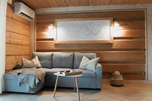 a living room with a blue couch and wooden walls at Willa Madejówka - Apartamenty z Widokiem na Góry i Wanną z Jacuzzi in Ząb +79 photos