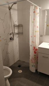 a bathroom with a shower curtain and a toilet at דירת 80 מ"ר למשפחה או זוג in Qiryat Bialik