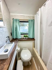 a small bathroom with a toilet and a sink at Cozy & Private Tiny House Style in Hickson