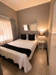 a bedroom with a large bed with a window at Zhantique Guest House 2- Unit 5 in Boksburg +15 photos