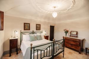 a bedroom with a bed and a chandelier at B&B Palazzo Agrippa in Bominaco