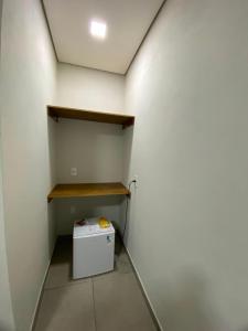 a small white refrigerator in a room with a wall at Hotel Grajaú in Arcos