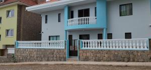 a white house with a blue and white balcony at Sunrise house in Ribeira Grande