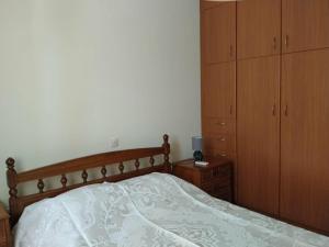 a bedroom with a bed and a wooden cabinet at Waves and Wonders Apartment in Korthi