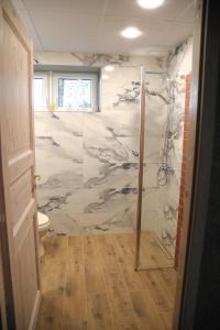 a bathroom with a shower with a marble wall at Voore Korterid in Ohukotsu +7 photos