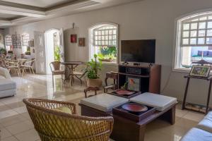 a living room with a couch and a tv at Pousada Boulevard in Cabo Frio