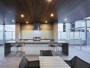 a kitchen with a large island with bar stools at The Sebel West Perth in Perth