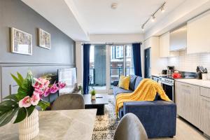 a living room with a blue couch and a kitchen at Filmos Hotel and Suites in Toronto