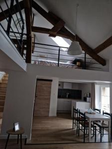 a kitchen and living room with a staircase and a table at Le Logis de Meung Sur Loire in Meung-sur-Loire
