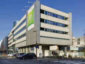 a large building with cars parked in a parking lot at ibis Styles Massy Opéra in Massy