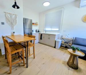 a living room with a table and a kitchen at Noy Hosting in the Golan in Nov