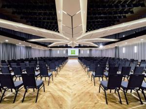 a large room with rows of chairs in front of a screen at ibis Styles Nowy Targ in Nowy Targ
