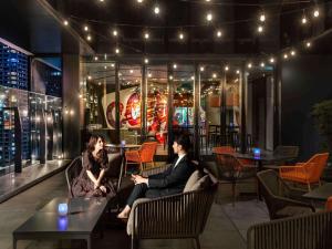 two people sitting in chairs in a restaurant at night at Pullman Tokyo Tamachi in Tokyo