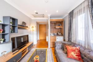 a living room with a couch and a tv at The King Suit Beşiktaş in Istanbul