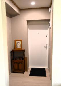 a hallway with a white door and a table at Voore Korterid in Ohukotsu