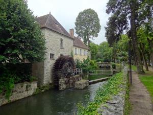 an old building next to a river in a park at Centre Nemours - Climatisation - Cosy Deluxe in Nemours