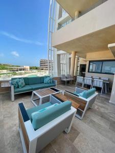 a patio with couches and tables on a building at Beachfront condo in Progreso in Telchac Puerto