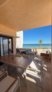 a dining room with a table and chairs and the beach at Beachfront condo in Progreso in Telchac Puerto