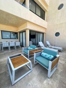 a patio with couches and tables in a building at Beachfront condo in Progreso in Telchac Puerto