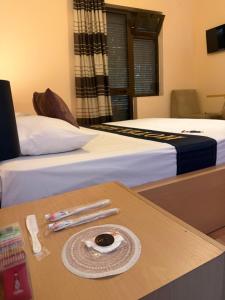 a hotel room with two beds and a table with a plate on it at Algo Hotel Tirana in Tirana