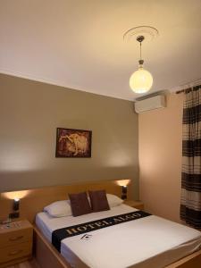 a bedroom with a bed and a light on the ceiling at Algo Hotel Tirana in Tirana