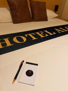 a pen andepad on a bed with the word hotel at Algo Hotel Tirana in Tirana
