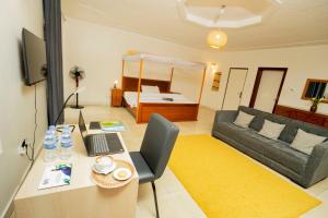 a room with a desk with a laptop and a couch at Nature Kigali in Kigali