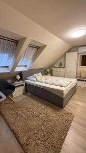 a bedroom with a large bed and a rug at Atkári Vendégház in Bóly