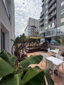 a patio with tables and chairs and buildings at Durres Beach Rooms in Durrës