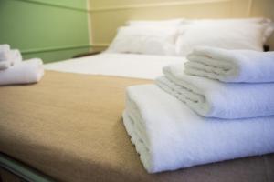 a room with two beds with white towels on them at Oro Hotel in Policoro +2 photos
