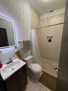 a bathroom with a toilet and a sink and a shower at Departamentos MIRAMONTES in Guaymas