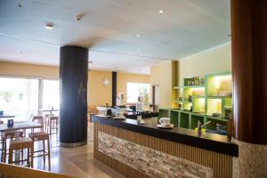 a restaurant with a bar and tables and chairs at Oro Hotel in Policoro