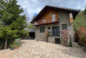 a stone house with a balcony and a patio at Villa Albani in Peje