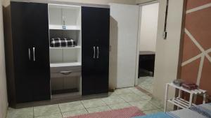 a bedroom with black cabinets and a room with a bed at Casa cantinho da Rubi in Atibaia +7 photos