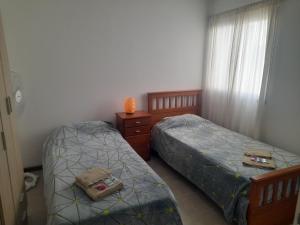 a bedroom with two beds and a dresser and a window at Complejo Vélez Sarsfield 185 in Bell Ville