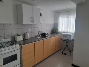 a kitchen with a sink and a stove top oven at Complejo Vélez Sarsfield 185 in Bell Ville