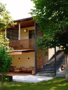 a house with a deck and benches and stairs at Racha Roots Boutique House in Ambrolauri