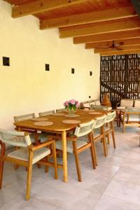 a wooden table with chairs and a vase of flowers on it at Racha Roots Boutique House in Ambrolauri