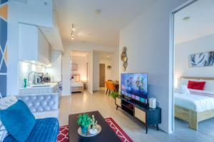 a living room with a bed and a tv at Filmos Hotel and Suites in Toronto