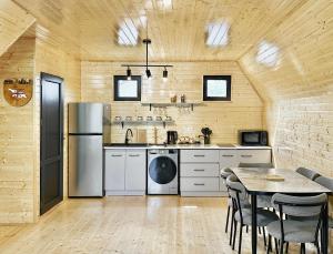 a kitchen with a refrigerator and a table with chairs at Kaniore Cottage in Martvili
