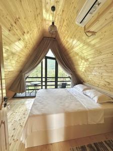 a bedroom with a large bed with a wooden ceiling at Kaniore Cottage in Martvili