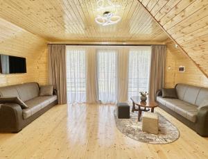 a living room with two couches and a table at Kaniore Cottage in Martvili