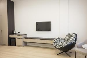 a living room with a chair and a tv at Lchak Hotel in Yeghegnadzor