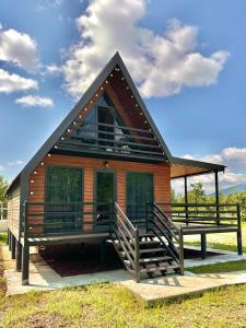 a small house with a large porch and a deck at Kaniore Cottage in Martvili