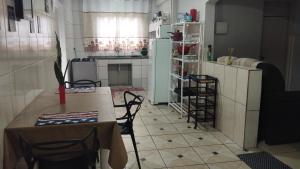 a kitchen with a table and chairs and a refrigerator at Casa cantinho da Rubi in Atibaia
