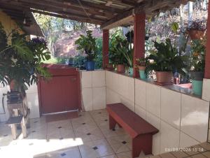 a bench in a room with potted plants on it at Casa cantinho da Rubi in Atibaia