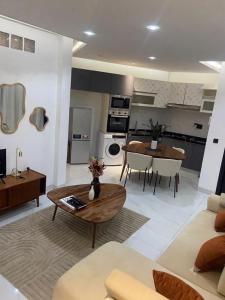 a living room with a couch and a table at Elegance appart-Yoff virage in Dakar